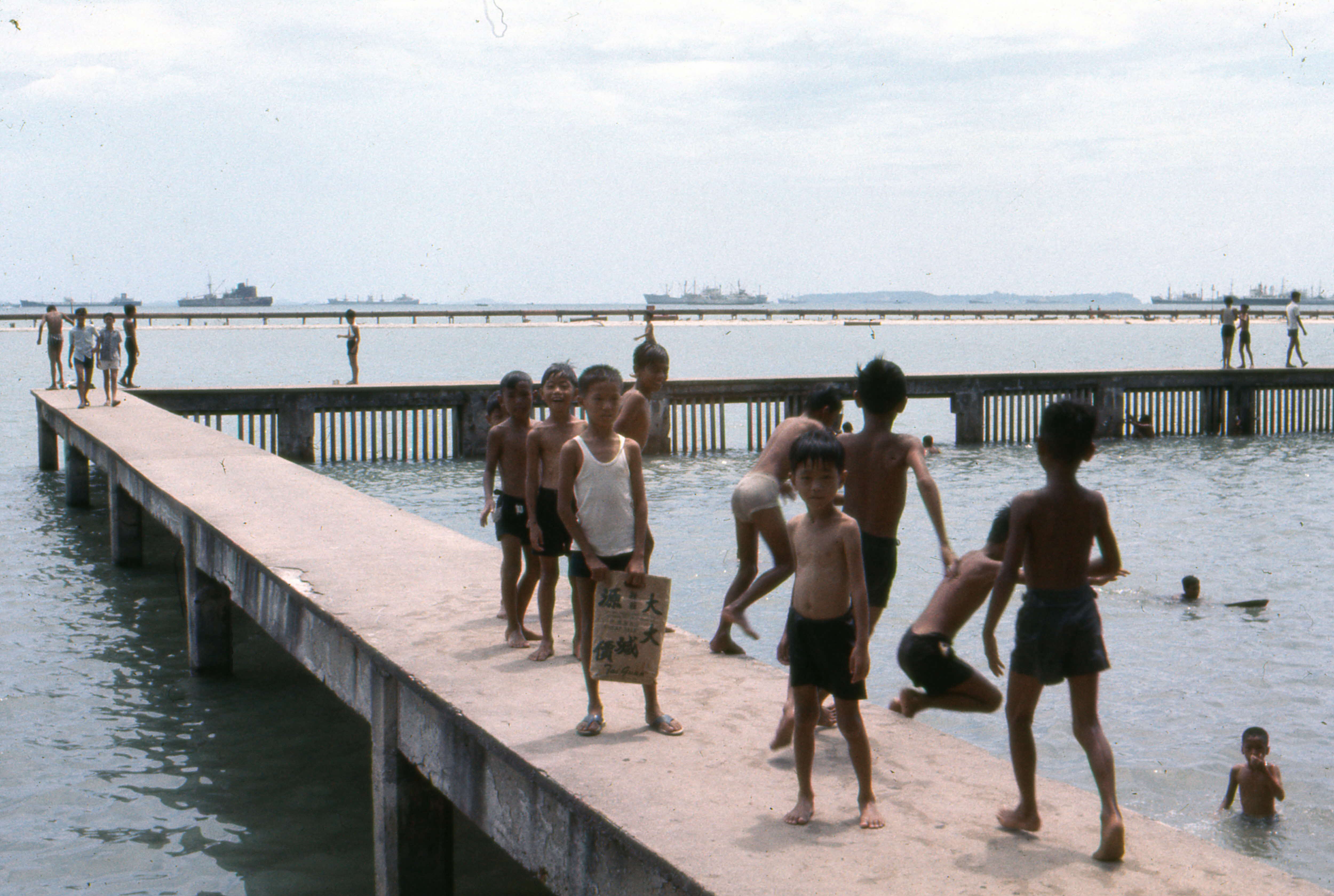 Children frolicking at the raised platform of the Katong Park bathing pagar, 1969.
